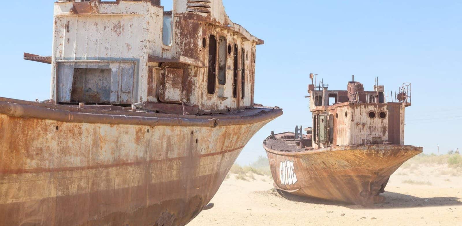 Rustic boats on a ship graveyards on a desert around Moynaq