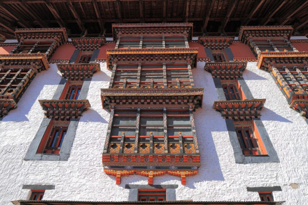 A breathtaking image of Rinpung Dzong, a fortress-monastery perched on a hilltop overlooking Paro Valley, boasting traditional Bhutanese architecture and vibrant colors.
