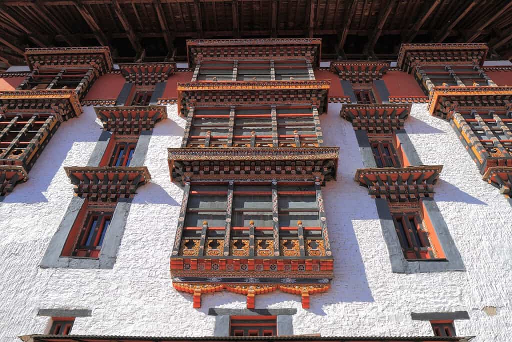 A breathtaking image of Rinpung Dzong, a fortress-monastery perched on a hilltop overlooking Paro Valley, boasting traditional Bhutanese architecture and vibrant colors.